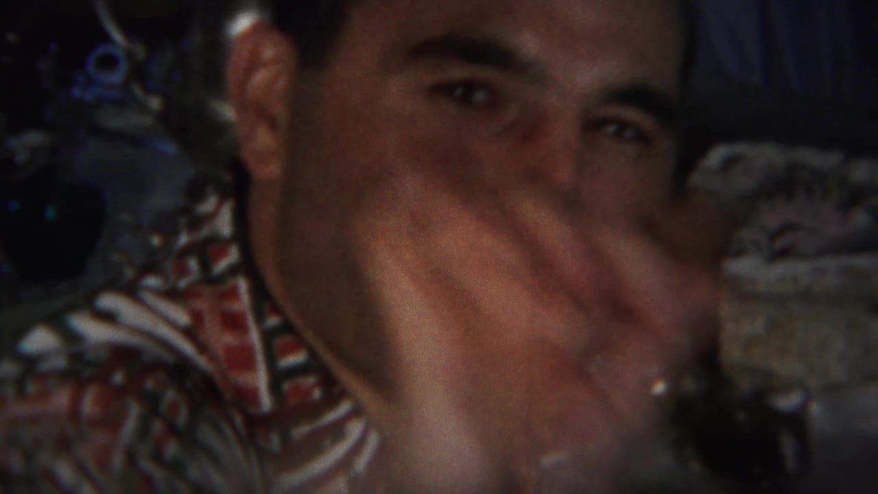 A man in a patterned shirt looks toward the camera and gestures near his face in 1951 Westville home-movie footage.