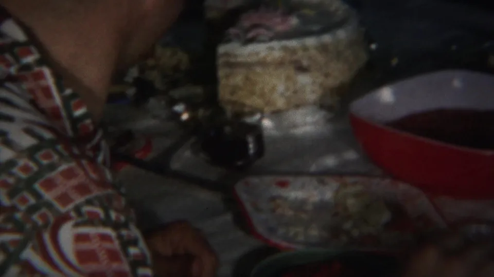 A man remains partly in frame near bowls, cups, and dishes at an indoor 1951 Westville gathering.