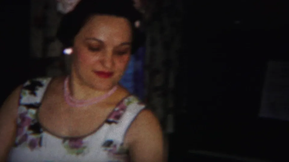 The woman in 1951 Westville footage looks down slightly, showing her floral white dress, earrings, and pink necklace.
