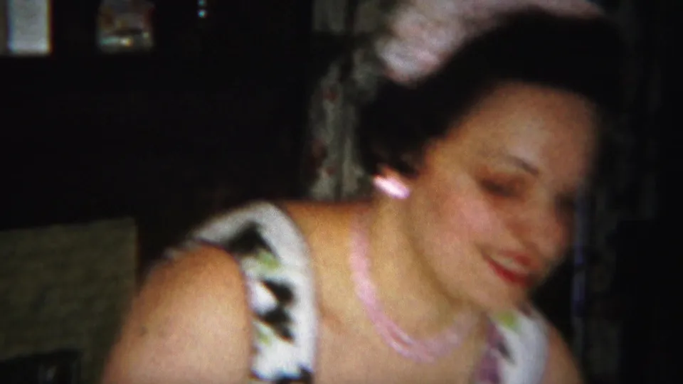 The woman moves through the final 1951 Westville frame, her face and floral dress softened by motion blur and low indoor light.
