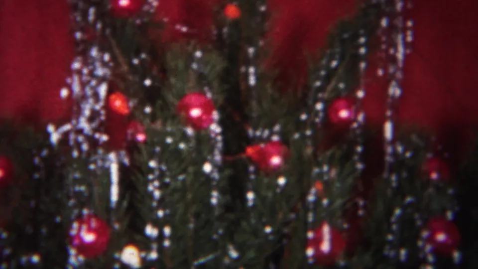 Close-up of a Christmas tree decorated with red ornaments and silver tinsel in a 1951 Westville home-movie scene.