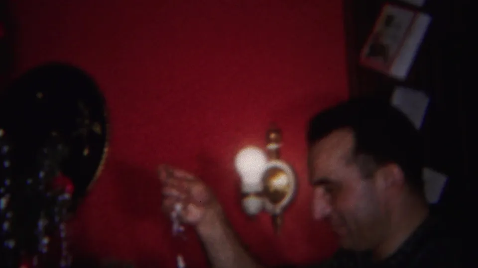 The man holds a small Christmas decoration near the tinsel-covered tree inside the red-walled Westville home.