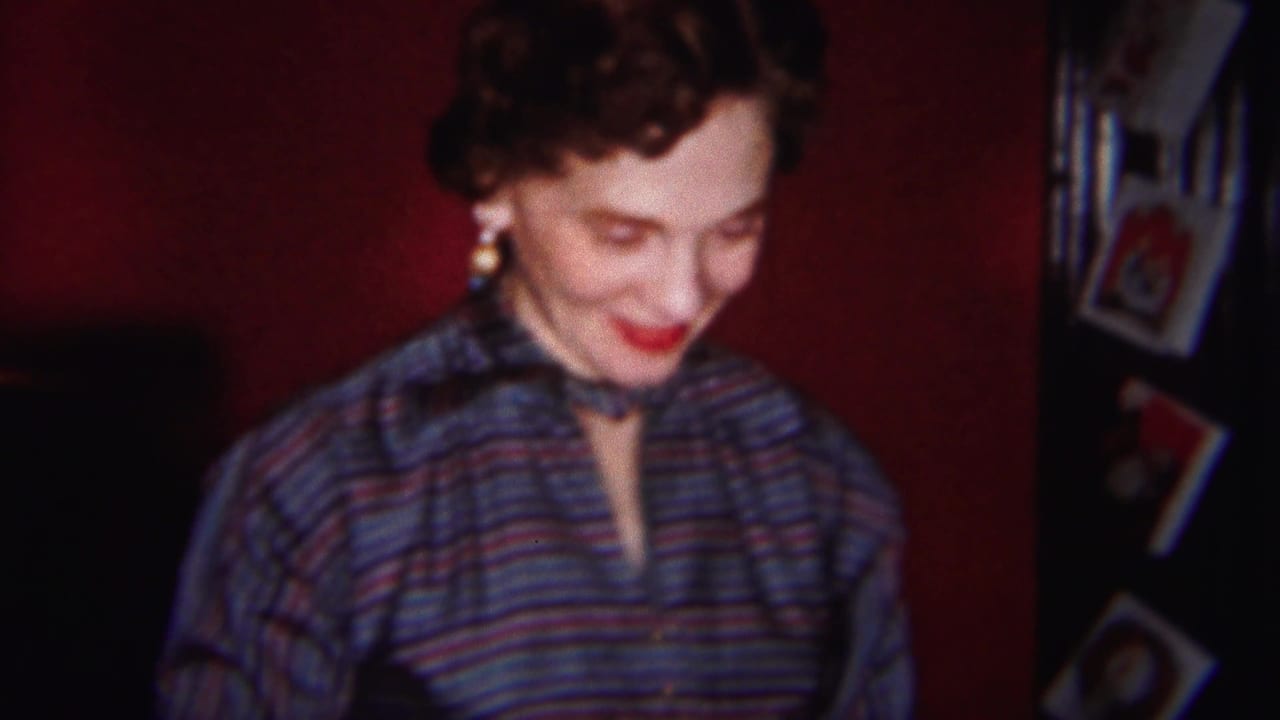 The woman remains in soft focus, smiling with her head lowered near small framed pictures in the Westville interior.