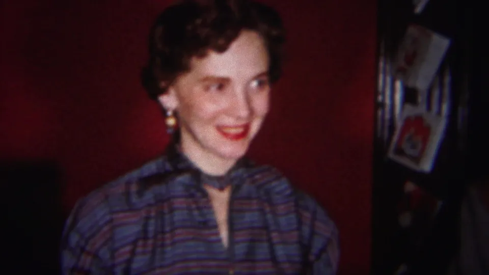 A woman in 1951 Westville footage turns to one side with a bright smile, wearing earrings, lipstick, and a striped shirt.