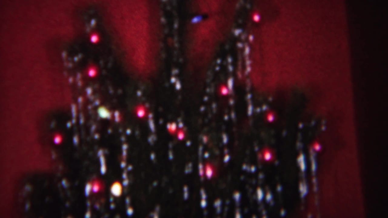 1951 home-movie frame from Westville showing the upper portion of a tinsel-covered Christmas tree in soft low light.