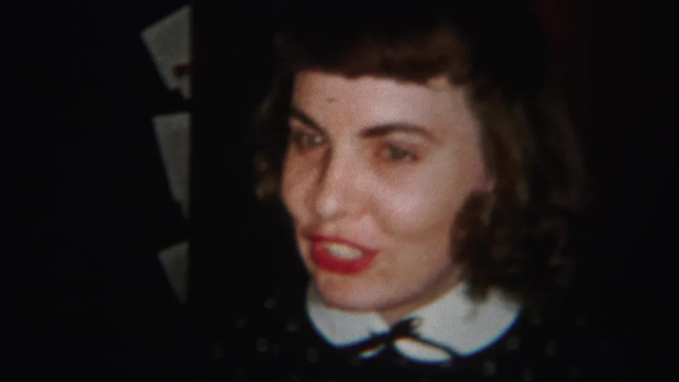 The woman appears mid-conversation in the 1951 Westville home movie, with her white collar, small bow, red lipstick, and curled hair visible.