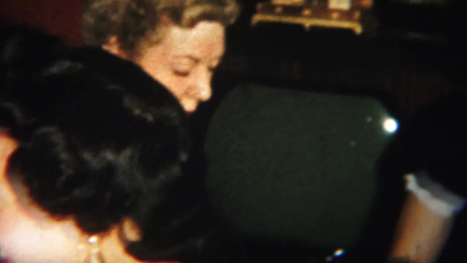 Adult women gather closely around the cards in a dim Westville interior, with dark green chair backs filling the foreground.