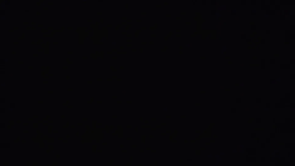 1951 8mm frame from Westville metadata showing a mostly dark, blurry abstract pattern with faint rounded forms and visible film grain.