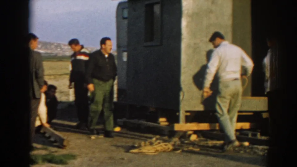 In Ephesus, Turkey in 1962, several adult men stand near a portable structure while one handles rope on the ground.