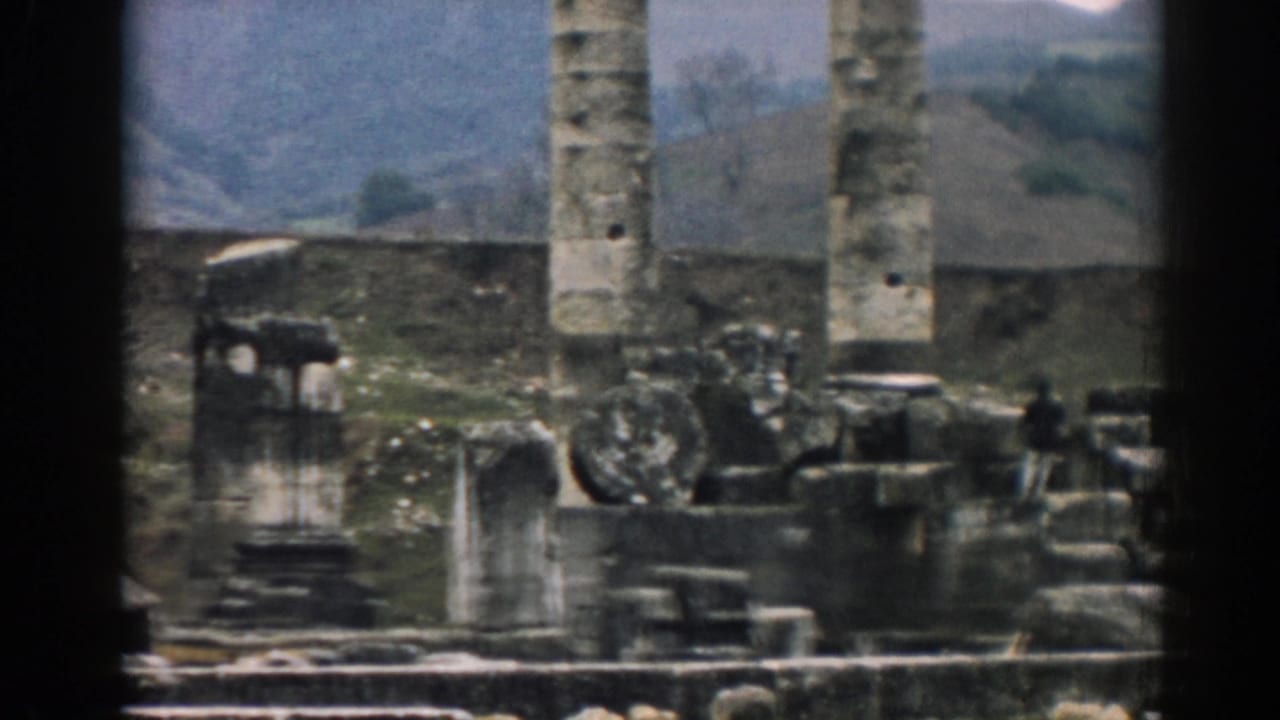 1962 8mm view of Ephesus ruins with tall stone columns, broken masonry, and rolling hills beyond the site.