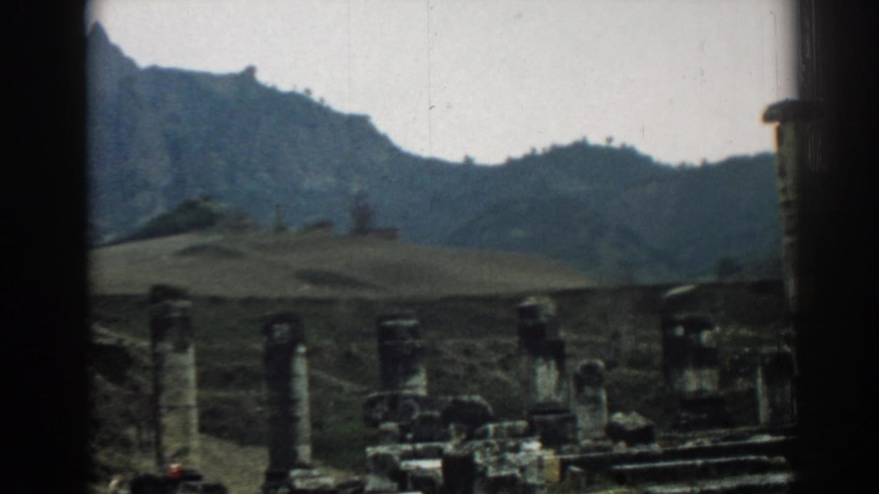 End of the 1962 Ephesus pan showing low ruins, scattered stone blocks, a hillside backdrop, and the edge of a column at far right.