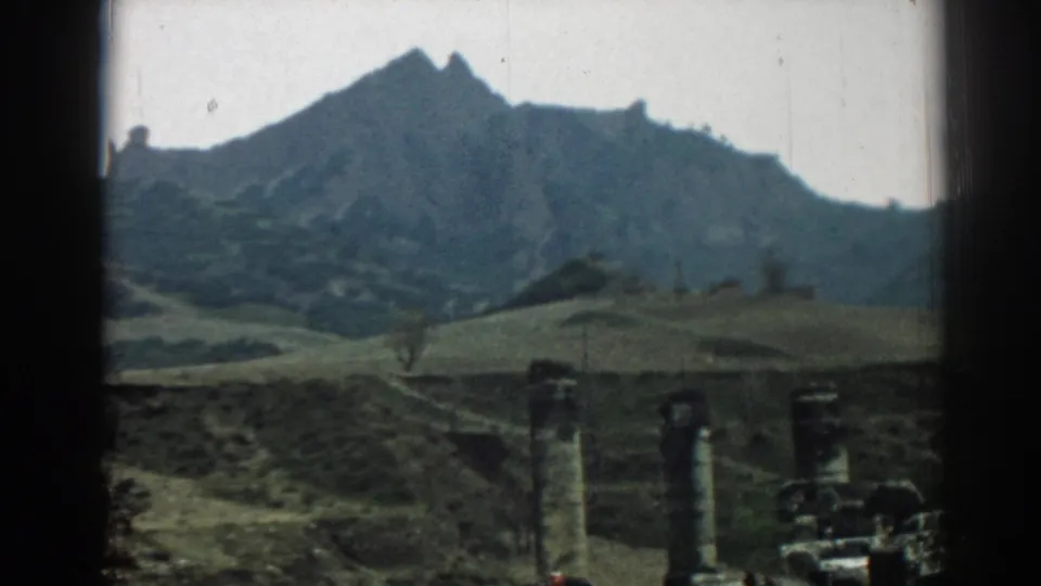 The 8mm frame shows Ephesus ruins low in the foreground, with rolling terrain and a rugged mountain forming the backdrop.