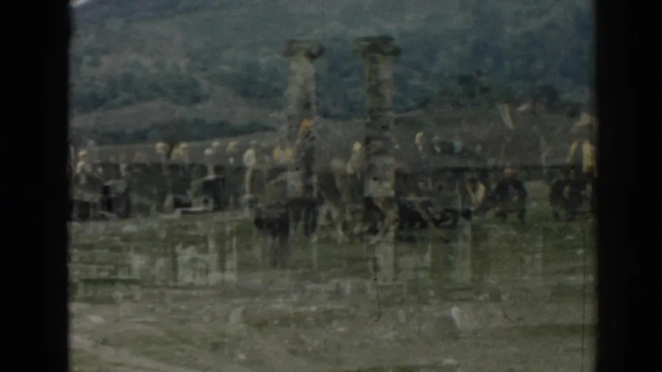 Tourists appear near columns, horses or carts, and parked vehicles at the Ephesus ruins in a soft 8mm frame.