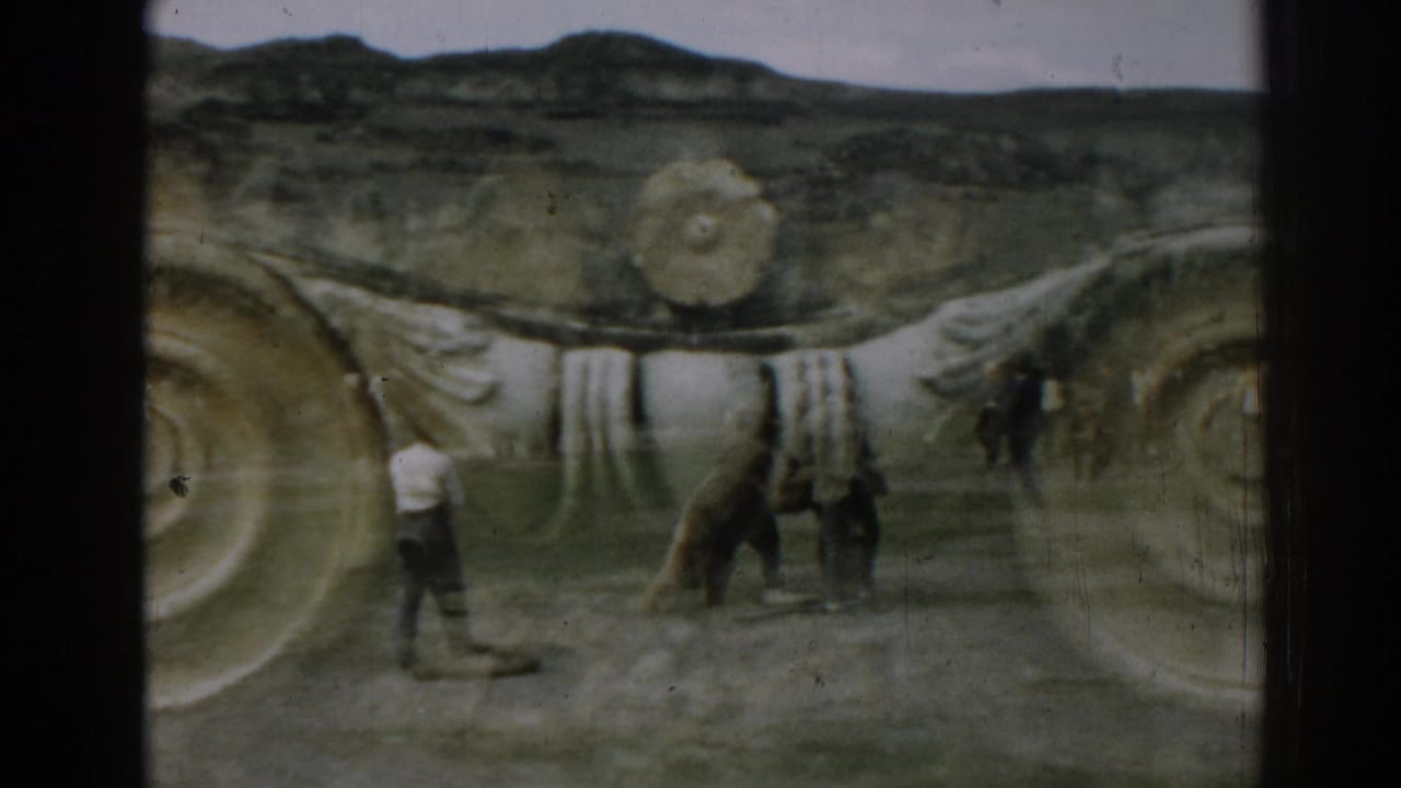 At Ephesus in 1962, a tan bear appears to walk with two men across an open area in front of ancient stonework.