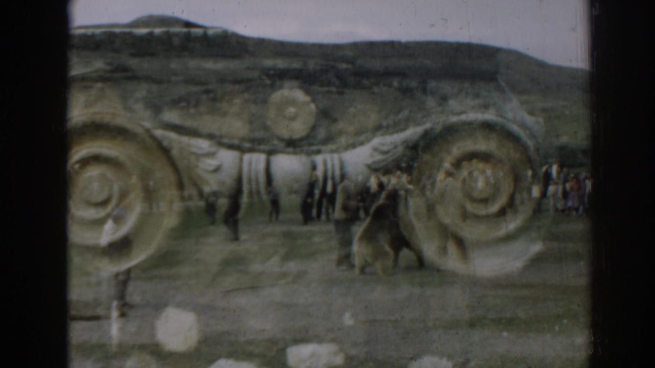 Near the end of the 1962 Ephesus clip, the bear and men pause or turn by spiral stonework as visitors stand farther back.