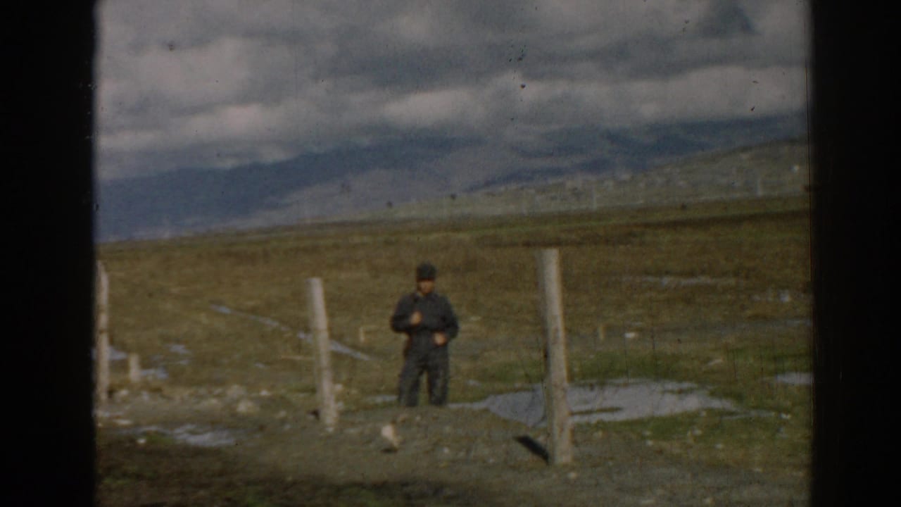 1962 8mm frame from Ephesus, Turkey showing a man standing alone among posts and rough ground.