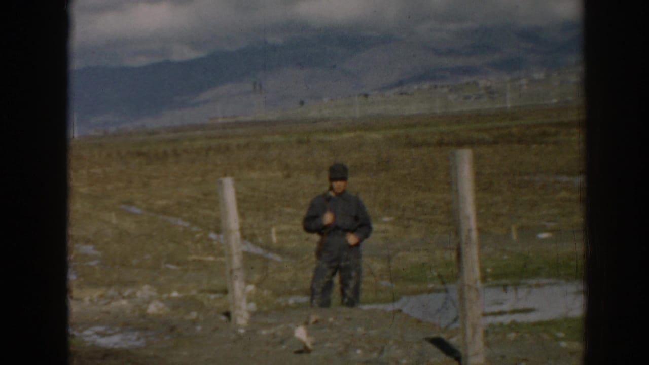 1962 8mm frame from Ephesus, Turkey with a closer view of a solitary man beside posts in a rural landscape.