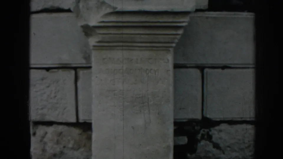 1962 Ephesus frame showing an inscribed stone pedestal or block in front of stacked masonry.