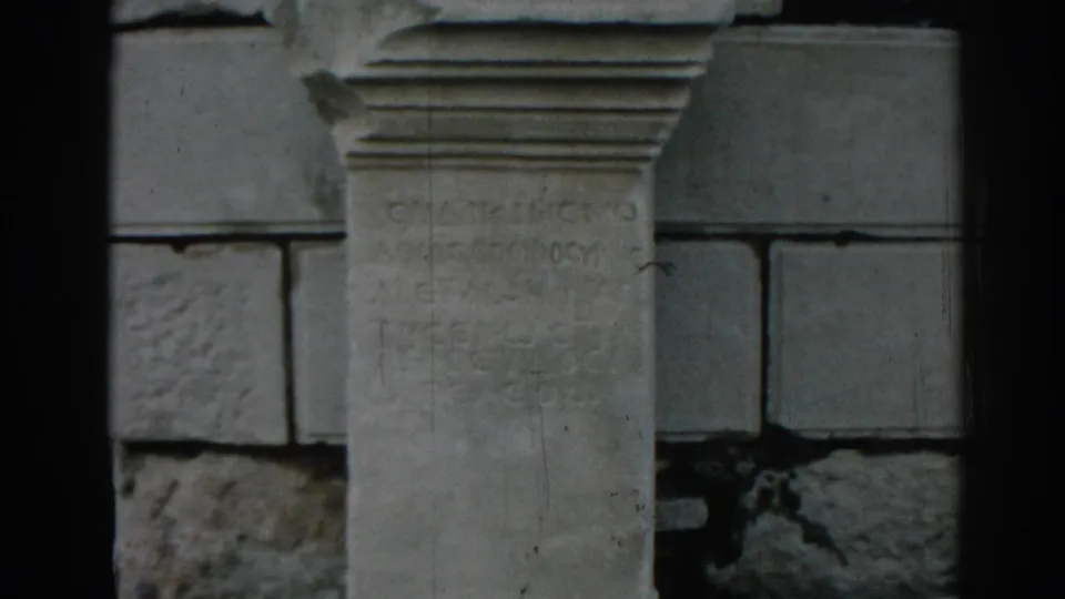 Visitor-shot 8mm frame at Ephesus focusing on a pale stone inscription set against darker surrounding blocks.