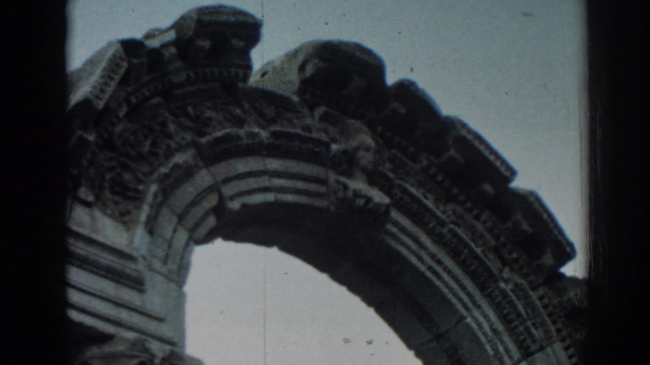 1962 Ephesus frame showing an ornate stone arch and decorative ruin details from below.