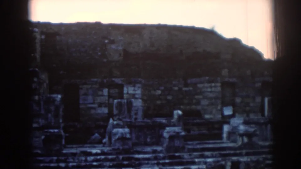 1962 Ephesus footage showing weathered stone ruins, steps, and columns after the camera moves away from the sign.