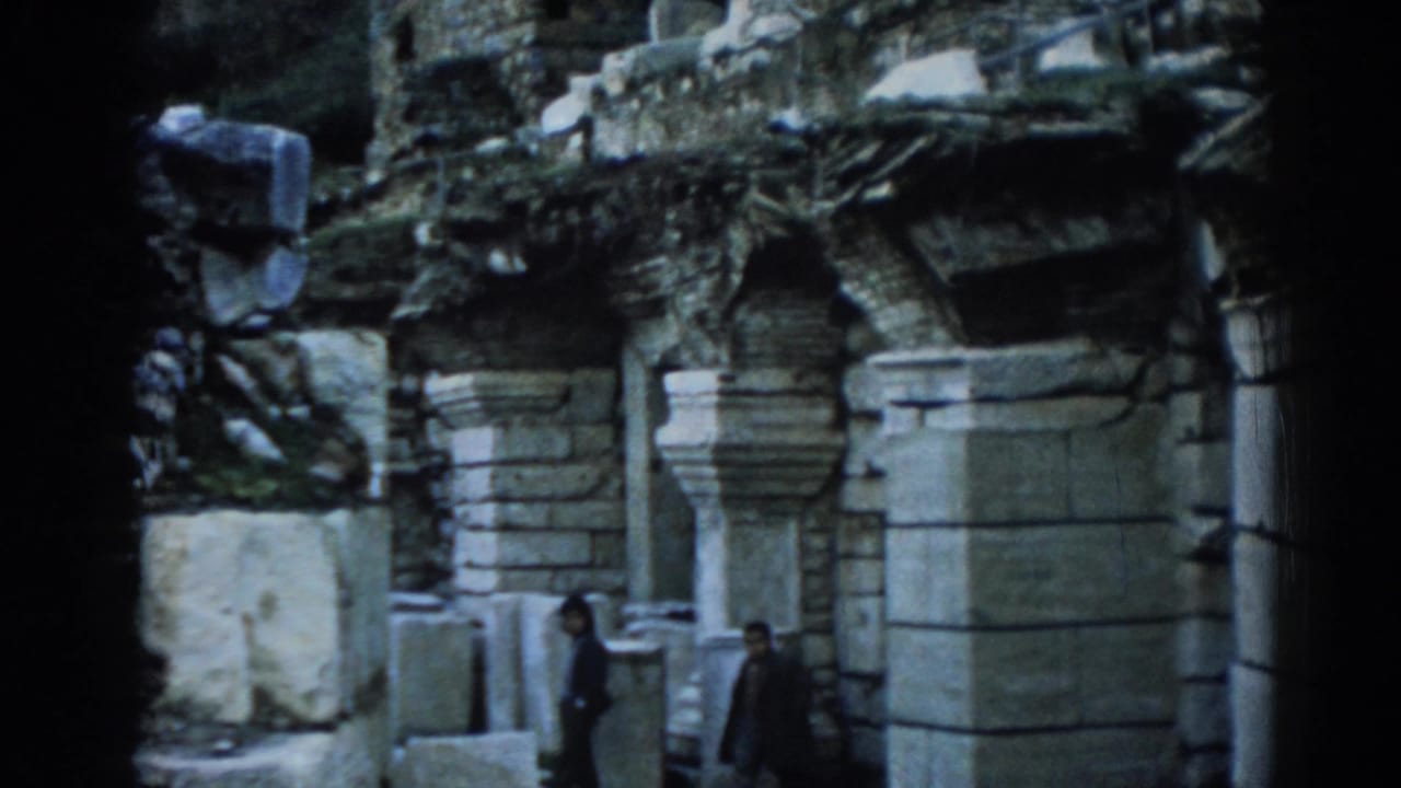 1962 8mm frame at Ephesus showing visitors near stacked masonry, columns, and weathered ruin walls.