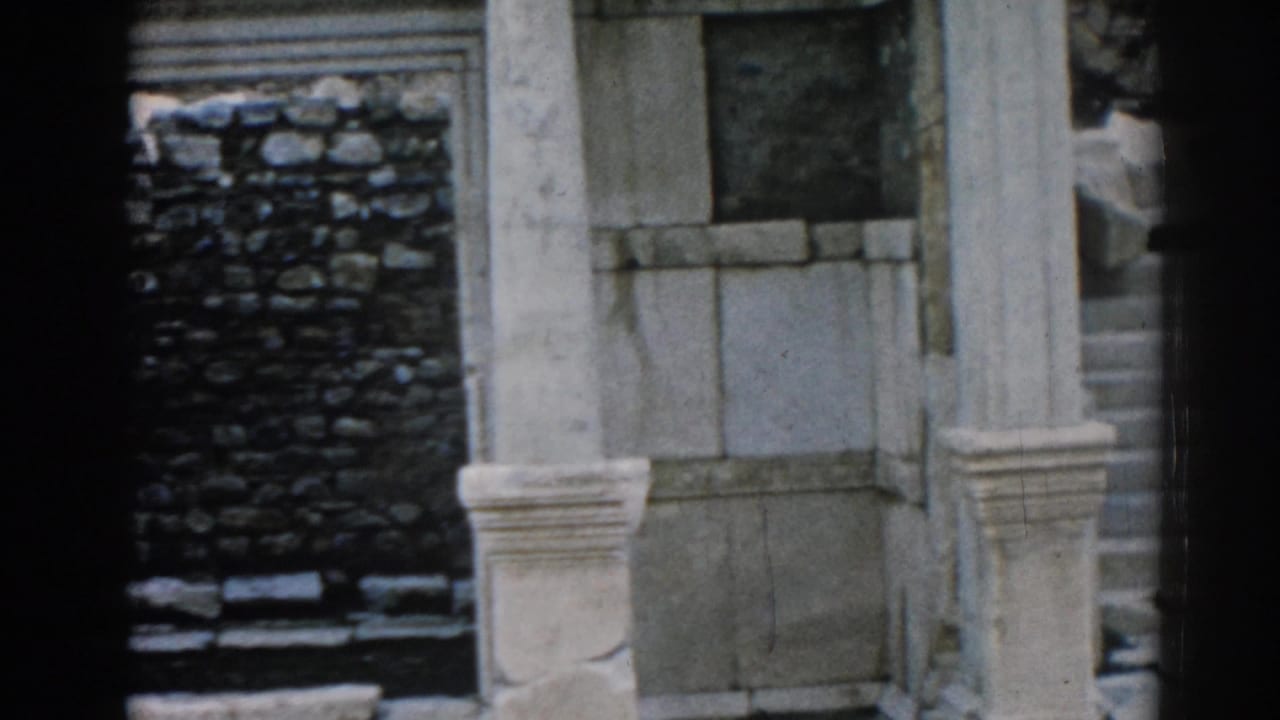1962 8mm view of weathered stonework and columns at the Ephesus ruins, with soft focus and dark frame edges.