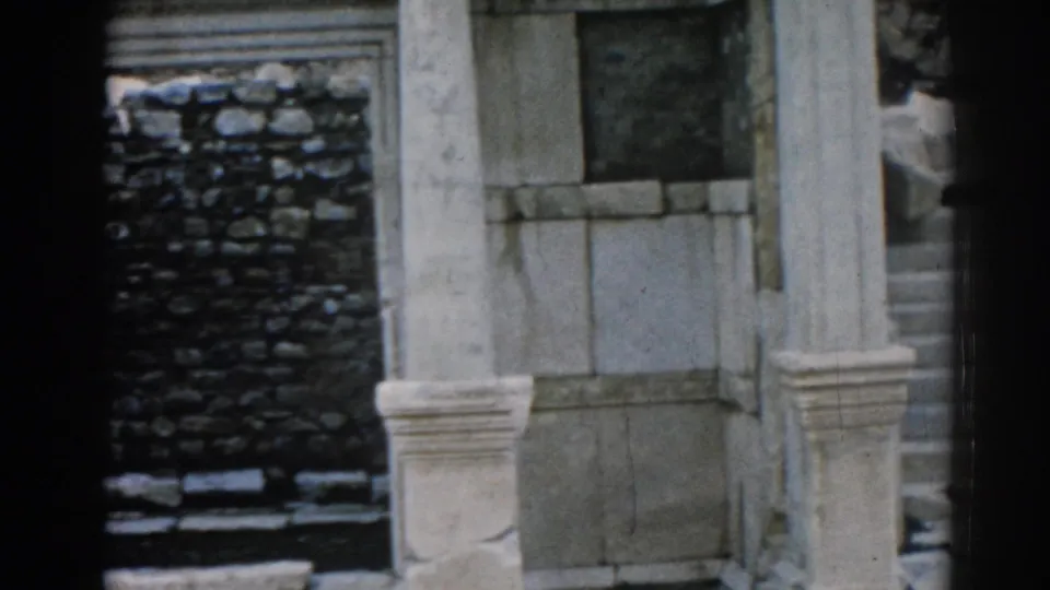 1962 8mm view of weathered stonework and columns at the Ephesus ruins, with soft focus and dark frame edges.