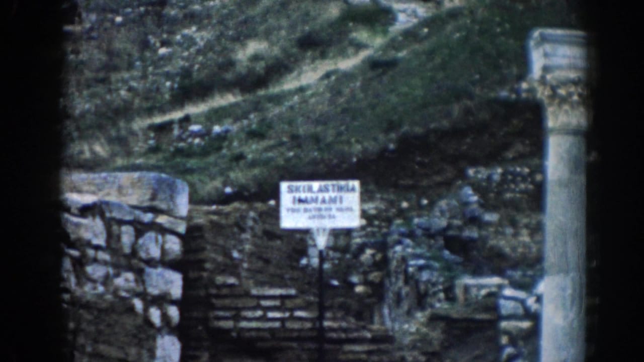 1962 Ephesus travel frame with a white sign reading Skulastikia Imamli near stone steps, walls, and a column.