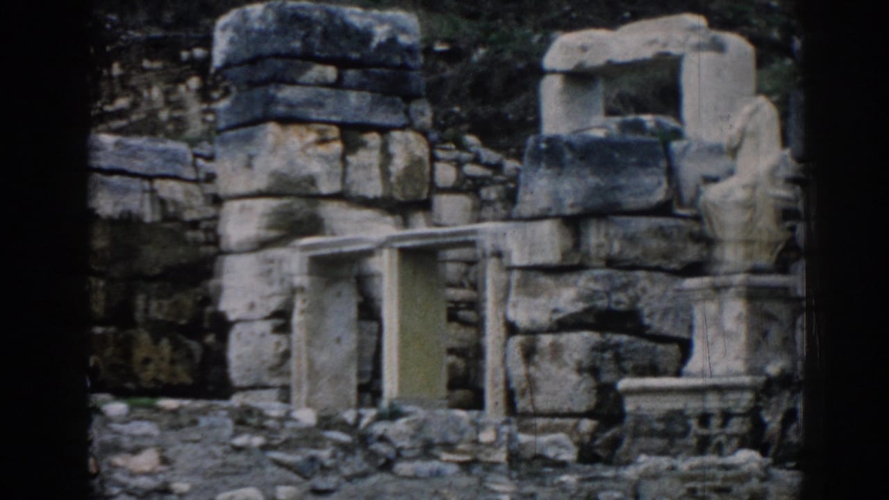 Stone ruins with block walls, carved pieces, and rubble in a dark-edged 8mm frame.
