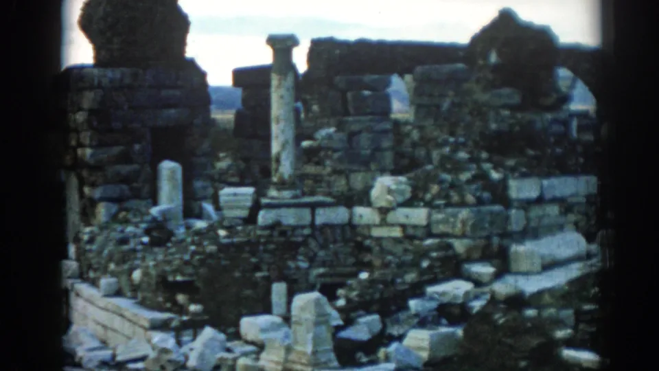 1962 Ephesus ruins frame showing weathered columns, stacked masonry, scattered stones, vegetation, and handheld 8mm framing.
