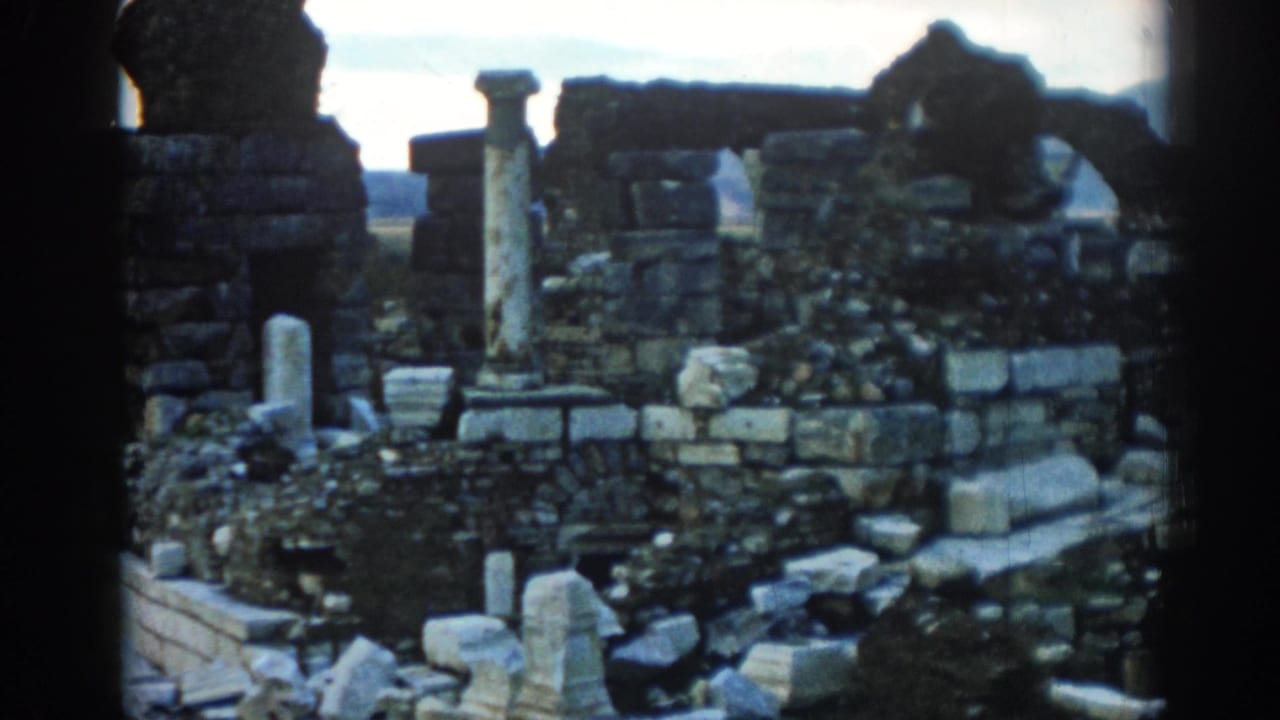 Stone ruins with scattered blocks, a standing column, and dark 8mm frame edges.