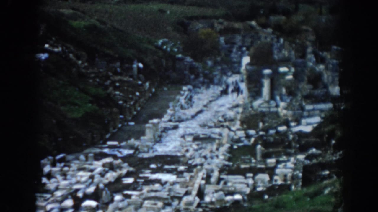 Ephesus archaeological ruins in 1962 home-movie footage, showing a bright stone path, column fragments, and distant tourists.