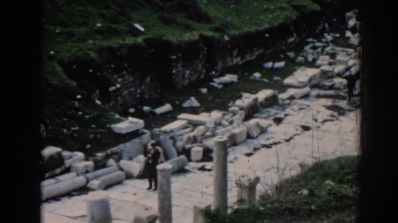 1962 Ephesus home-movie view of a visitor among upright columns, broken masonry, and a sunlit stone walkway.