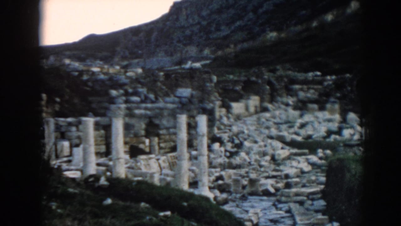 Visitor-shot 1962 Ephesus footage with pale columns, collapsed stones, and hillside terrain in soft 8mm color.