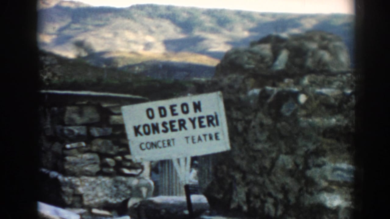 Odeon Konser Yeri sign beside stone ruins and rocky hillside.