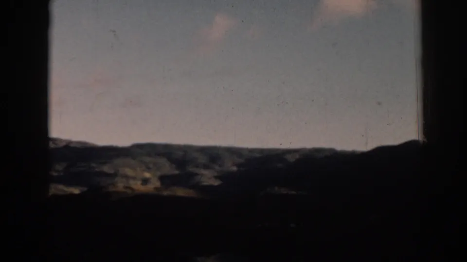 Late frame from the 1962 Ephesus, Turkey clip, holding on rolling hills and soft sky within dark home-movie framing.