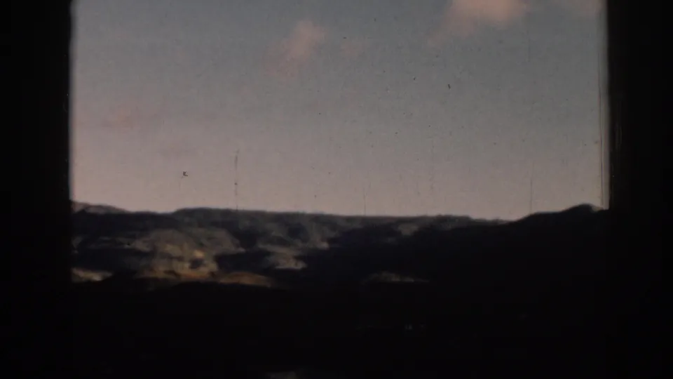 1962 Ephesus travel footage showing distant hills under a pale sky, framed by a dark opening.