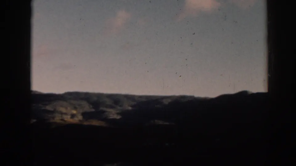 A static 8mm view of rolling hills near Ephesus, with a pale blue sky and dark framing edges.