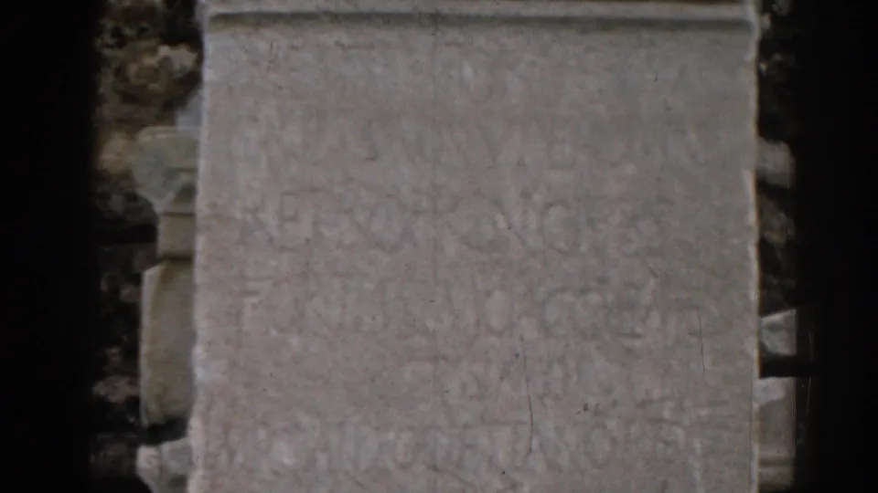 Close 1962 Ephesus travel-film view of a weathered stone slab with faint inscriptions and soft, grainy 8mm texture.