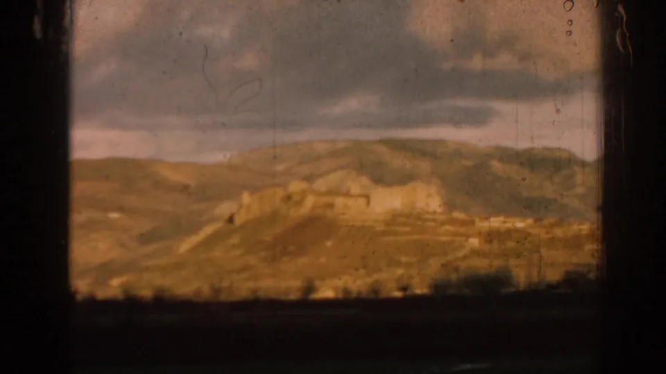 1962 Ephesus-area landscape with rolling hills, distant ruin walls, cloudy sky, and warm faded 8mm color.