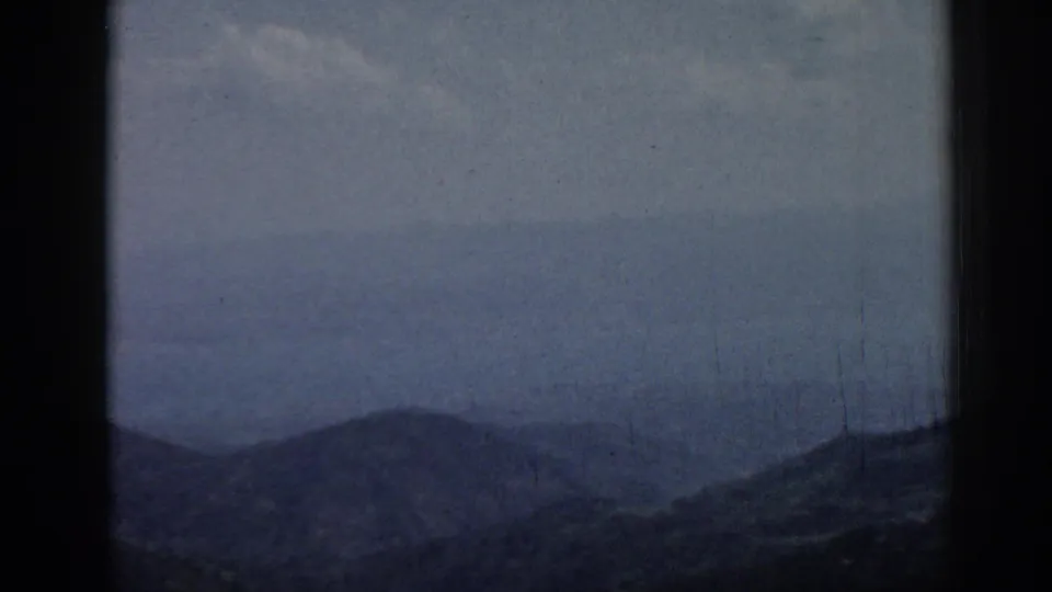 1962 8mm travel footage from Ephesus, Turkey, showing distant hazy mountain ridges through dark film gate edges.