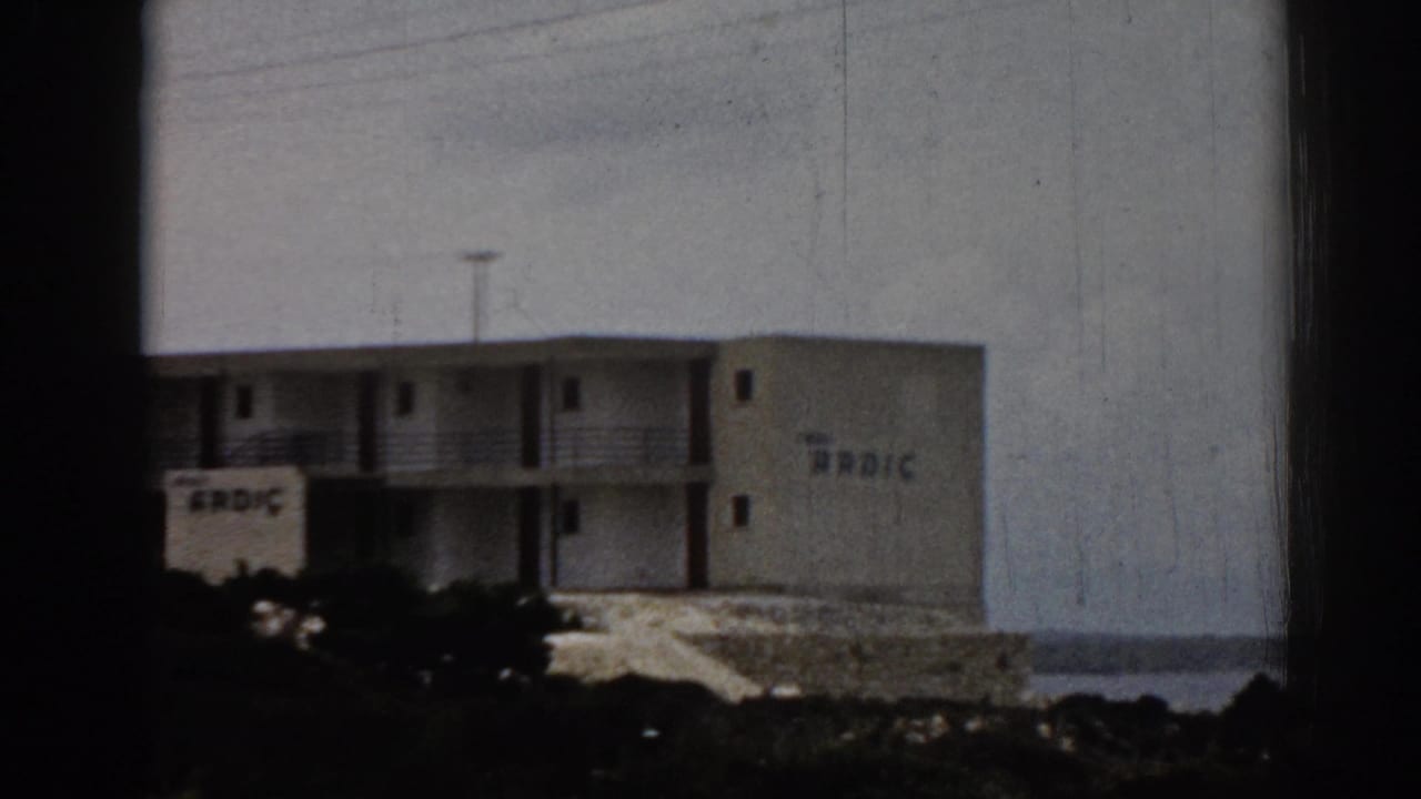 Hotel exterior with balconies and ARDIC lettering near the sea.