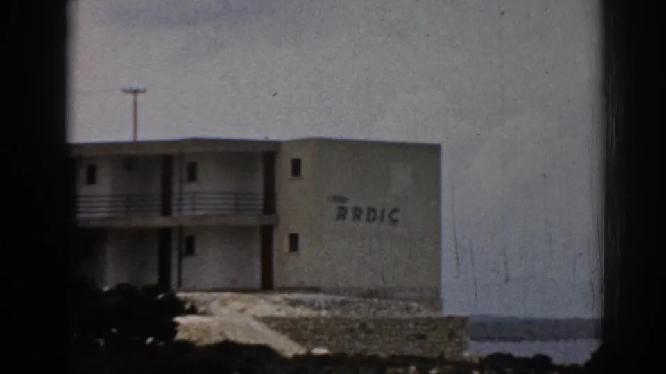 Zoomed 1962 Turkey frame emphasizing the hotel facade, balcony structure, ARDIC lettering, and shoreline setting.