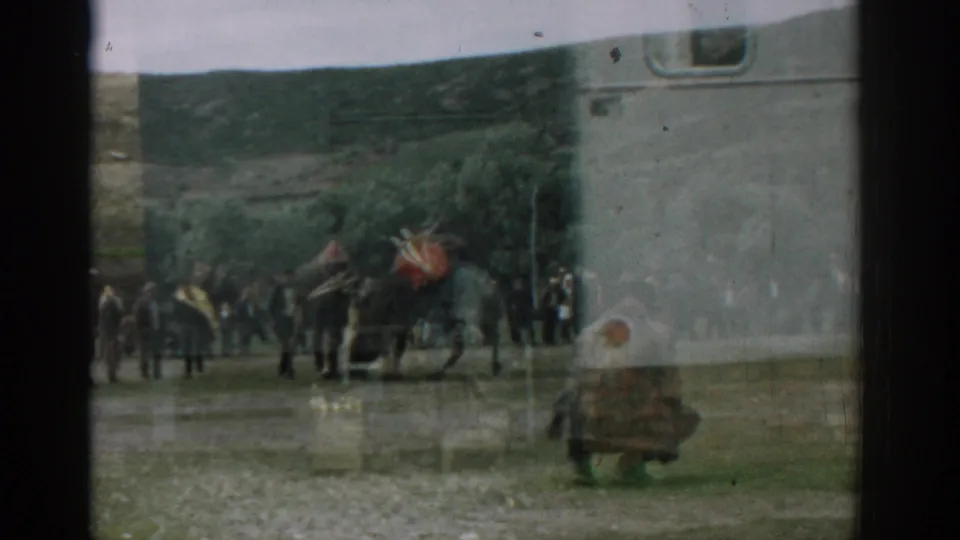 1962 Izmir footage shows a large animal with a red covering near a small group of men, partly obscured by vehicle glass and framing.