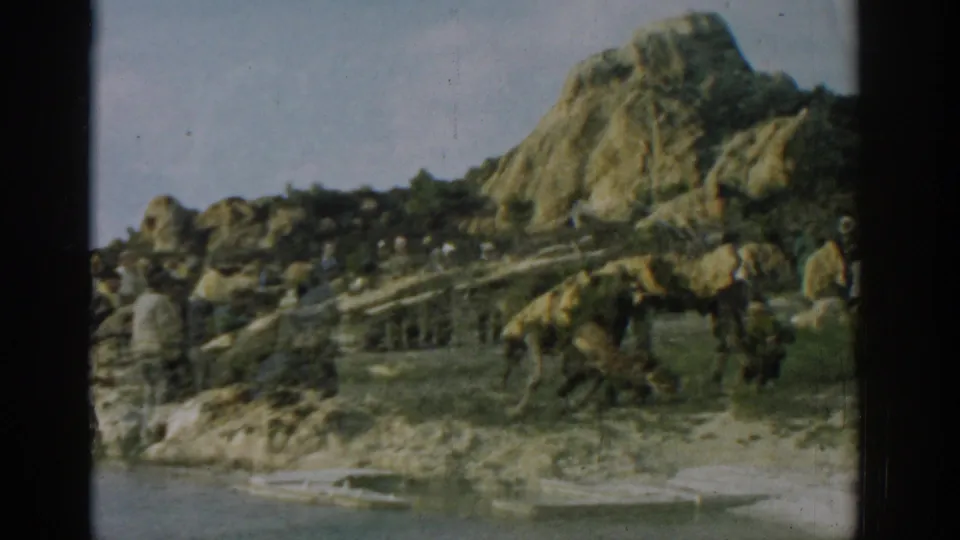 1962 Izmir 8mm frame showing a large animal close to the shoreline as bystanders observe from nearby rocks.