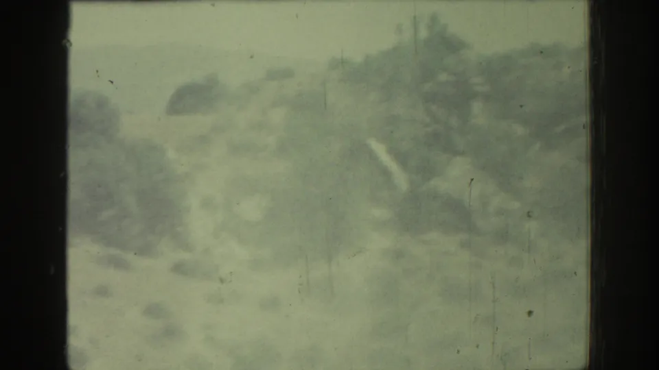 Soft, hazy 1962 8mm view of rocky hillside terrain in Rhodes, Greece, seen from inside a moving vehicle.