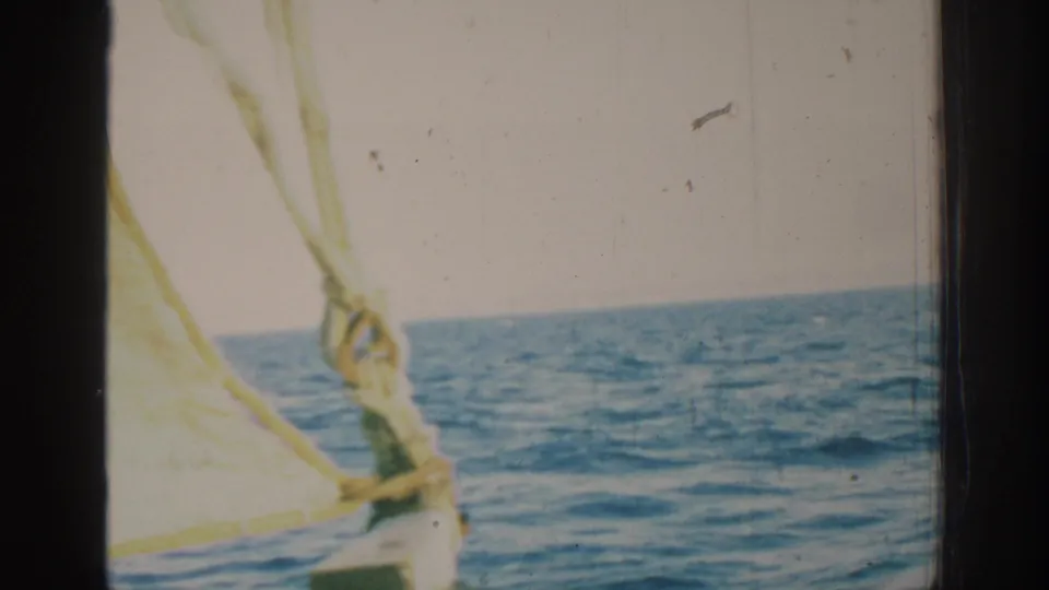 1962 Rhodes sailing footage showing open Mediterranean water with pale sailcloth and rope rigging in the foreground.
