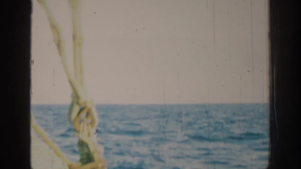 1962 Rhodes, Greece sailing view with a rope knot, rigging and horizon visible through dark vertical framing.