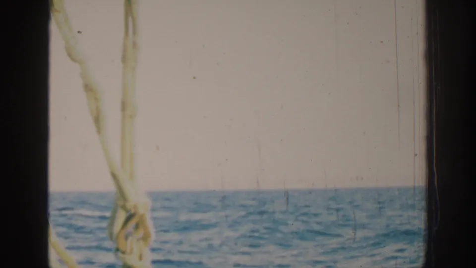 1962 Rhodes, Greece 8mm frame with boat rigging at left and open water under a pale sky.